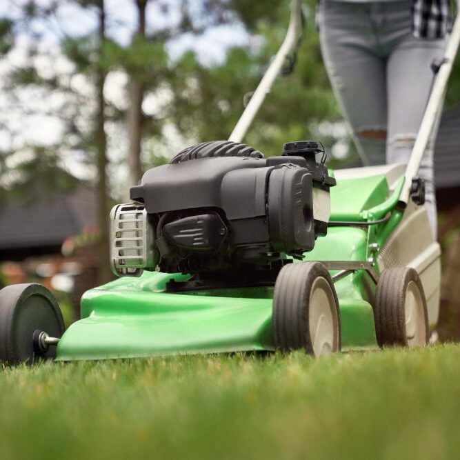 A worker using a mower for professional lawn care services.